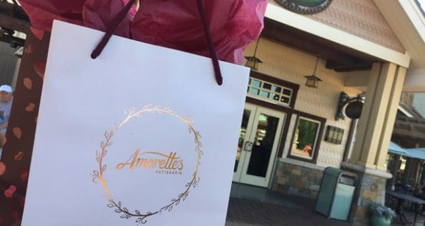 An Amorette’s Patisserie bag with pink tissue paper outside the bakery—just one sweet stop on your Disney Springs adventure.