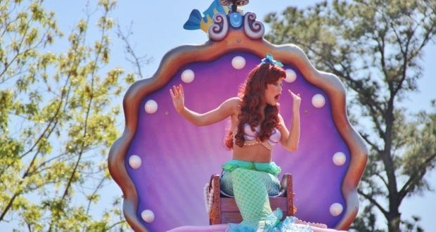 Ariel from The Little Mermaid waves from a vibrant seashell float in the parade, radiating Disney World magic.
