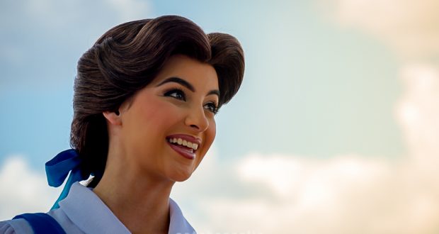Belle from "Beauty and the Beast" beams beneath a sunlit sky, enchanting guests with Disney’s signature character magic.