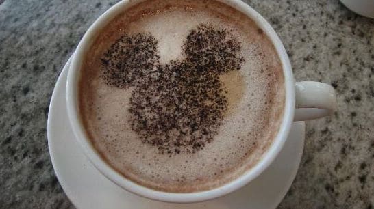 Savor Disney magic at the Grand Floridian Café—Mickey Mouse-shaped cocoa dusting tops a frothy cup of coffee.