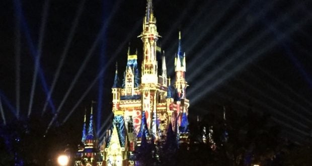 Cinderella Castle aglow in vibrant lights and dazzling beams, enchanting guests during Disney World’s iconic nighttime spectaculars.