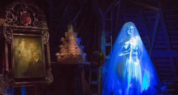The Haunted Mansion’s glowing ghost bride poses by a spooky portrait and wedding cake in a chilling, secret-filled Disney setting.