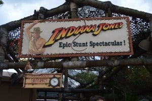 Indiana Jones Epic Stunt Spectacular!" sign at Disney’s Hollywood Studios, with Indiana Jones art and Fastpass Entrance clock.