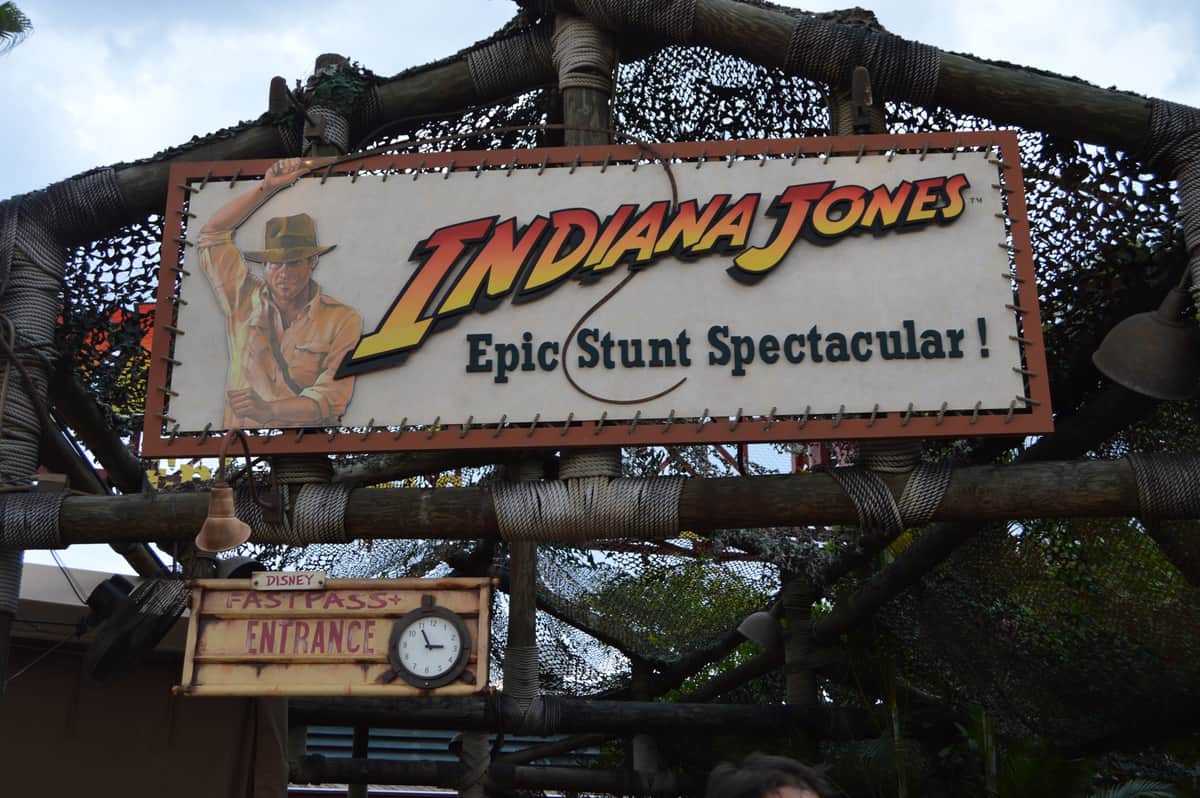 Indiana Jones Epic Stunt Spectacular!" sign at Disney’s Hollywood Studios, with Indiana Jones art and Fastpass Entrance clock.