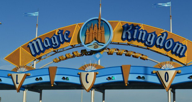 Magic Kingdom entrance sign with castle logo shines under a blue sky, inviting guests to start their Walt Disney World adventure.