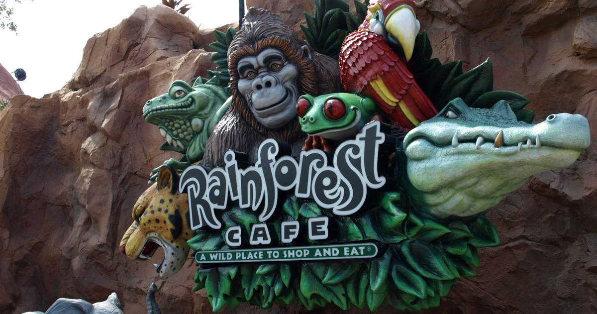 Rainforest Cafe sign with vibrant gorilla, parrot, frog, jaguar, and alligator sculptures at Disney’s Animal Kingdom entrance.