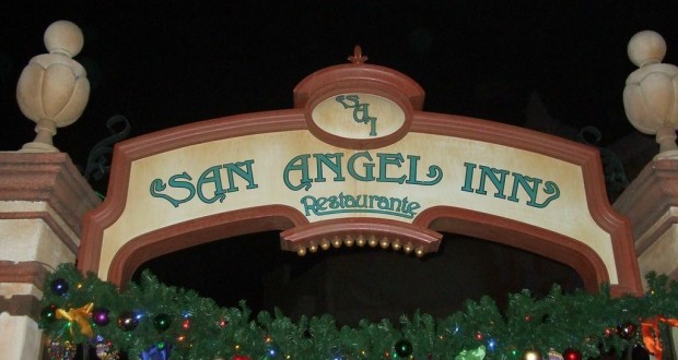 San Angel Inn Restaurante sign at Walt Disney World glowing amid festive garland and ornaments, capturing park holiday magic.
