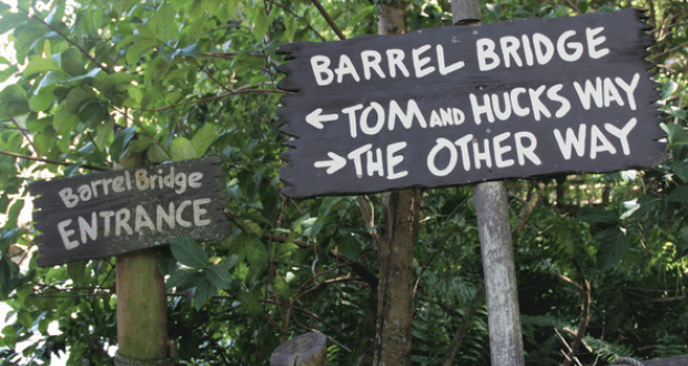 Barrel Bridge signs beckon adventurers: “Tom and Huck’s Way” or “The Other Way”—a hidden Magic Kingdom gem awaits!.