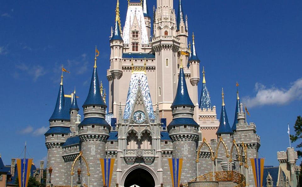 Cinderella Castle at Disney World, with iconic blue spires and gold accents shining under a clear sky—plan ahead for the magic!.