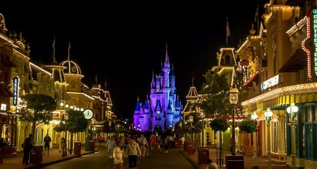 Main Street U.S.A. sparkles at night as crowds head toward Cinderella Castle, soaking up Disney World's magical energy.