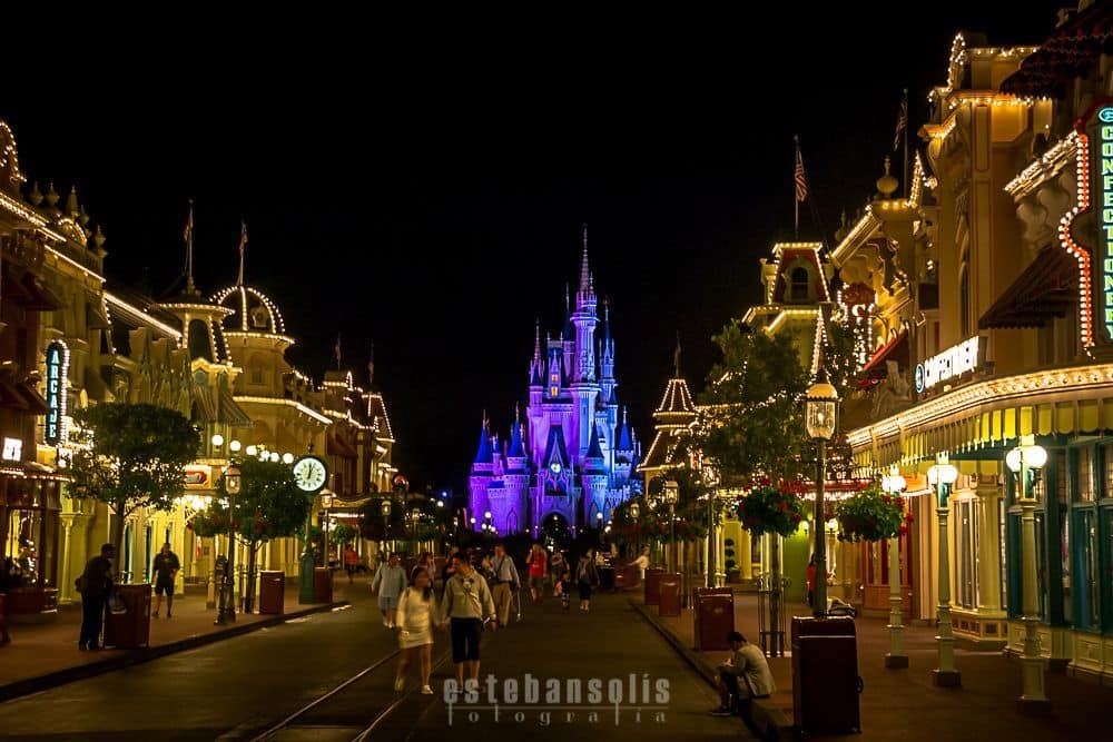 Main Street U.S.A. sparkles at night as crowds head toward Cinderella Castle, soaking up Disney World's magical energy.