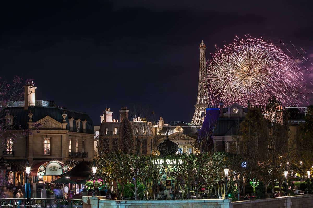 Epcot-inspired nightscape with Parisian buildings, Eiffel Tower, and dazzling fireworks show lighting up the sky in World Showcase.