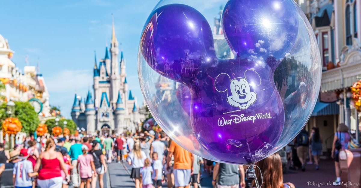 A purple Mickey Mouse balloon floats at Disney World, Cinderella Castle rising behind it as fans search for Hidden Mickeys in the crowd.