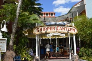 Guests gather outside the Skipper Canteen at Magic Kingdom, immersed in exotic jungle theming and vibrant greenery.