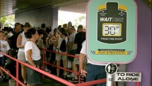 Visitors queue in Tomorrowland as the Indy Speedway sign posts a 30-minute wait time at Disney World.