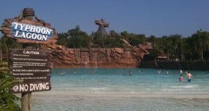 Typhoon Lagoon’s iconic wave pool with guests enjoying the surf, set against the backdrop of Miss Tilly shipwreck on Mt. Mayday.