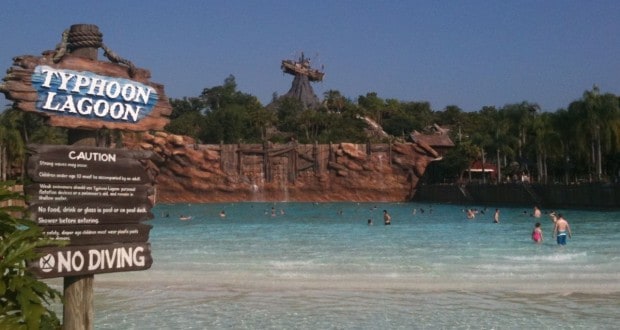 Typhoon Lagoon’s iconic wave pool with guests enjoying the surf, set against the backdrop of Miss Tilly shipwreck on Mt. Mayday.