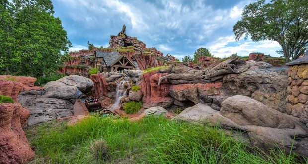 Vivid rocky scene with a wooden outpost and waterfall, lush greenery, all evoking the adventure of Disney World’s Hidden Mickey quest.