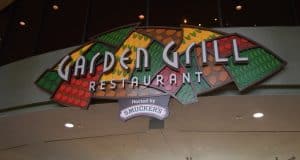 Stained glass "Garden Grill Restaurant" sign with "Hosted by Smuckers"—a hotspot for Hidden Mickey hunters at EPCOT.