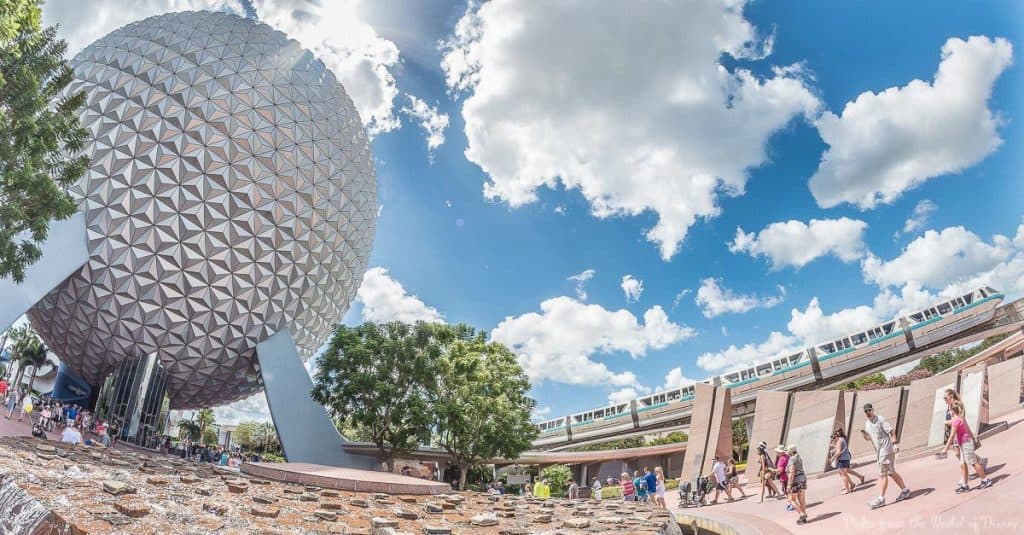 Spaceship Earth, the Epcot monorail gliding by, and excited guests exploring Disney’s futuristic park under a vibrant sky.