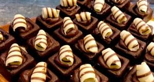 Disney World-inspired brownies lined up with dark chocolate swirls and white chocolate curls, just like park dessert treats.