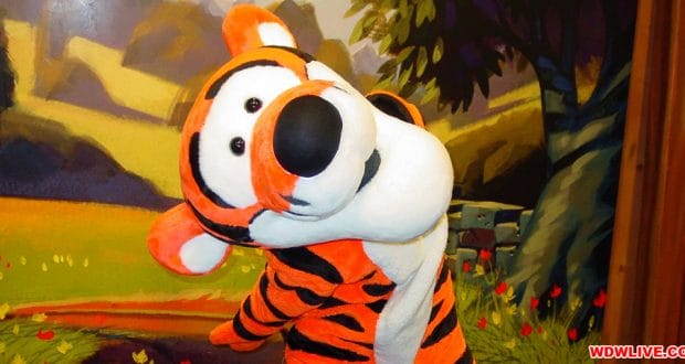 Tigger beams and strikes a playful pose in front of a themed backdrop, ready for magical meet and greets at Walt Disney World.