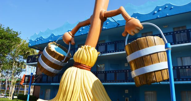 Fantasia’s iconic broomstick carrying buckets stands tall by Disney’s blue resort, a whimsical Disney World photo op in the sun.