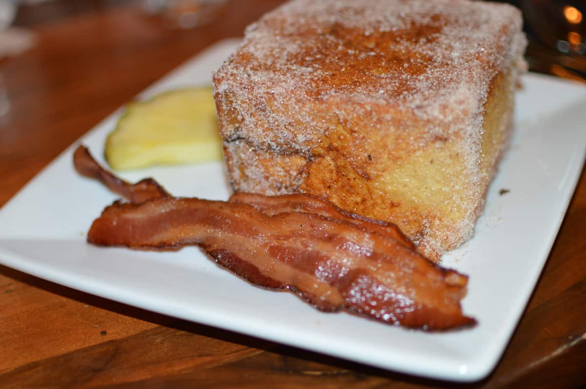 Cinnamon sugar toast, crispy bacon, and pineapple on a plate—a magical bite inspired by Disney World’s Quick Service secrets.