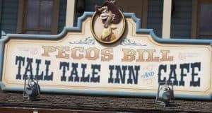 Pecos Bill Tall Tale Inn and Cafe sign with cartoon cowboy, highlighting a fan-favorite Disney World quick-service dining gem.