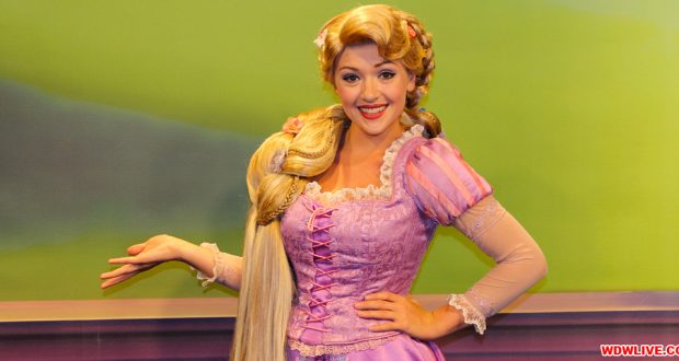 Rapunzel in her signature purple gown greets guests with a smile and wave against a vibrant green backdrop at Disney Parks.
