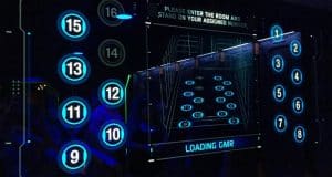Blue digital board with numbered circles and room assignments, evoking the thrilling vibe of Disney World attraction entrances.