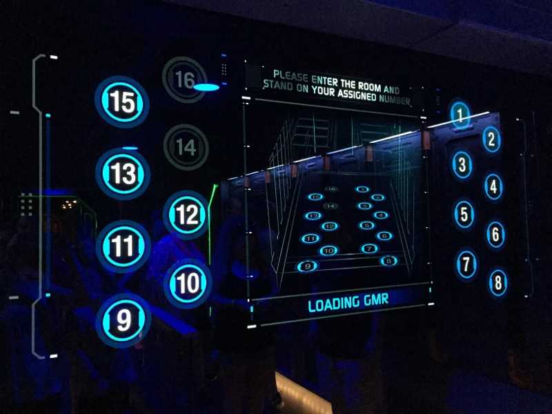 Blue digital board with numbered circles and room assignments, evoking the thrilling vibe of Disney World attraction entrances.