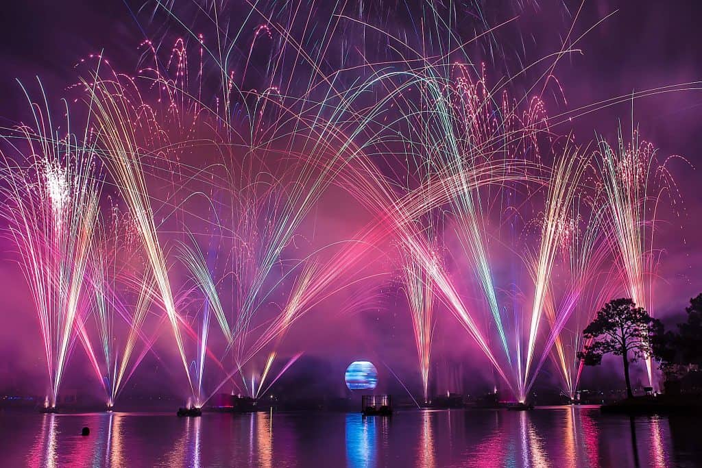 Spectacular fireworks dazzle above Disney World’s lake, their reflections shimmering as fans gather for the legendary nightly show.