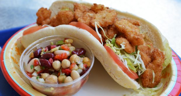 Enjoy a fried shrimp po’ boy with lettuce and tomato, plus bean salad—Disney World’s hidden foodie gem worth discovering.