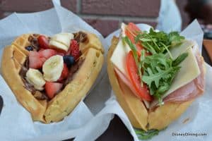 Heart-shaped waffles at Disney World: one topped with fruit and chocolate, the other savory with ham, cheese, tomato, arugula.