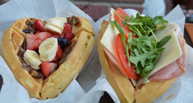 Heart-shaped waffles at Disney World: one topped with fruit and chocolate, the other savory with ham, cheese, tomato, arugula.