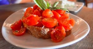Crispy bread with cherry tomatoes and basil, just like the flavorful bites served at Disney Deluxe Resorts’ signature dining spots.