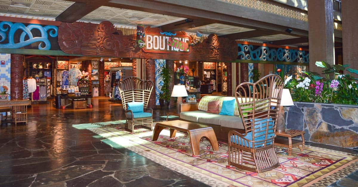 Deluxe Resort lobby at Disney World with tropical vibes, rattan seating, lush plants, and a boutique—pure Disney magic!.