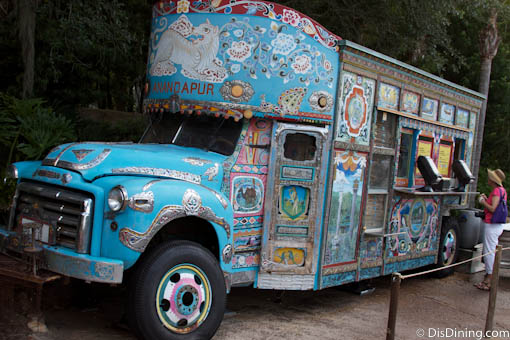 A whimsical blue food truck featuring elaborate patterns and playful animal art, like those found at Disney World, parked outside.