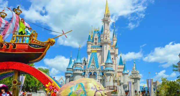 Vibrant parade float passing Cinderella Castle at Magic Kingdom, a must-see Disney World highlight on a sunny day.