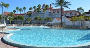 Sparkling pool flanked by palm trees and Disney Resort’s iconic red-roofed hotel—immerse in the magic of Walt Disney World.