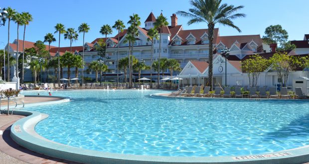 Sparkling pool flanked by palm trees and Disney Resort’s iconic red-roofed hotel—immerse in the magic of Walt Disney World.