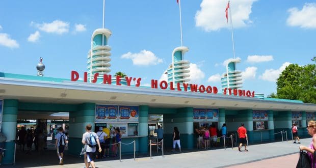 Disney’s Hollywood Studios entrance welcomes guests under sunny blue skies, buzzing with excitement at Walt Disney World.