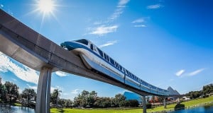 The Disney World Monorail glides above shimmering water under sunny skies, kicking off a legendary Monorail Bar Crawl.