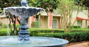 Elegant stone fountain flowing in Saratoga Springs Resort’s courtyard, near Disney resort villas and lush landscaping—pure Disney magic.