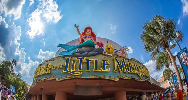 Ariel and Flounder welcome guests at The Little Mermaid attraction entrance, sparkling under the sun at Disney’s Hollywood Studios.