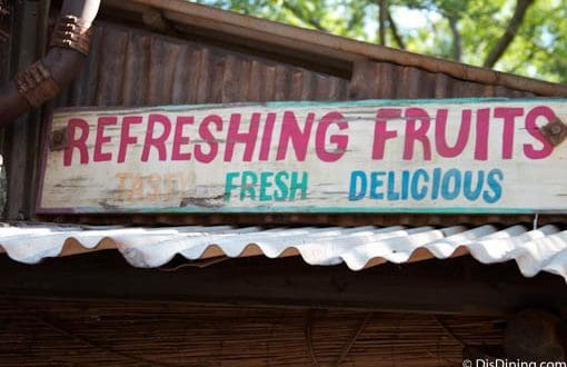 REFRESHING FRUITS Tasty Fresh Delicious" sign above a metal roof in Animal Kingdom—check nearby for snacks and photo ops!.