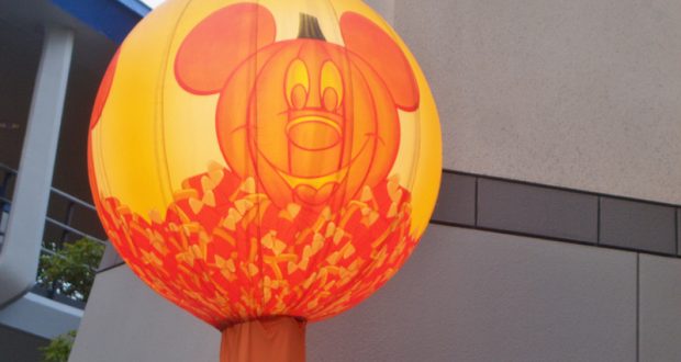 Giant inflatable Mickey Mouse pumpkin with candy corn accents decorates Main Street for a festive Disney Parks Halloween celebration.
