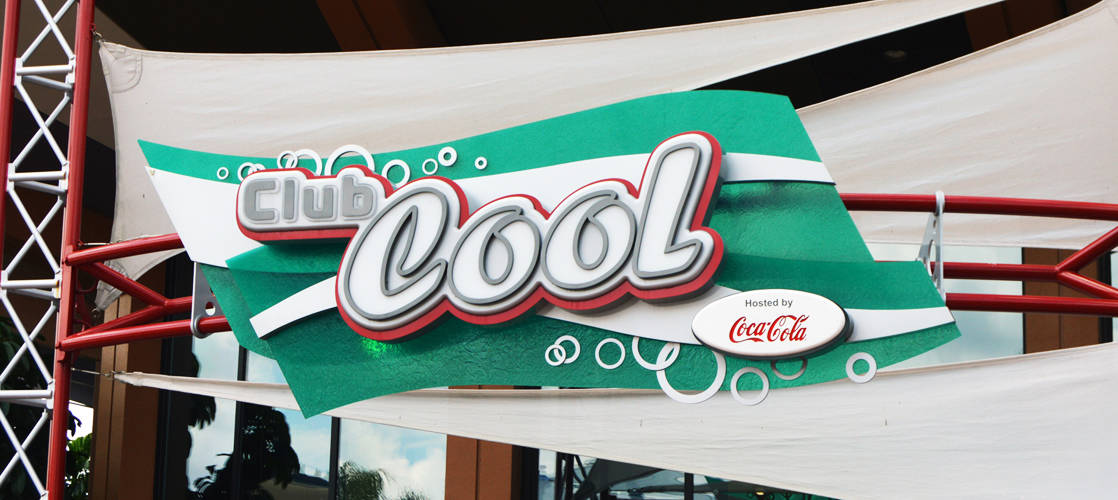 Club Cool’s classic green and white sign and Coca-Cola logo invite Epcot guests to cool off and sample international sodas.