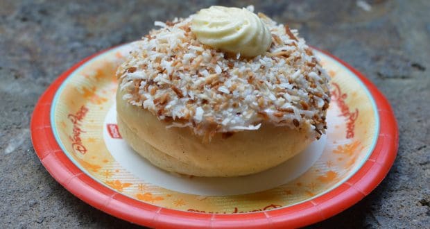 A delicious pastry with toasted coconut and cream on a Disney Parks plate—an Epcot World Showcase snack you can't miss!.